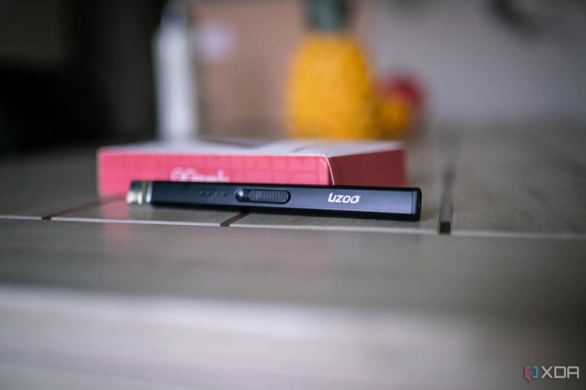 Bật lửa điện dùng cổng USB-C đang châm nến trên bàn làm việc.