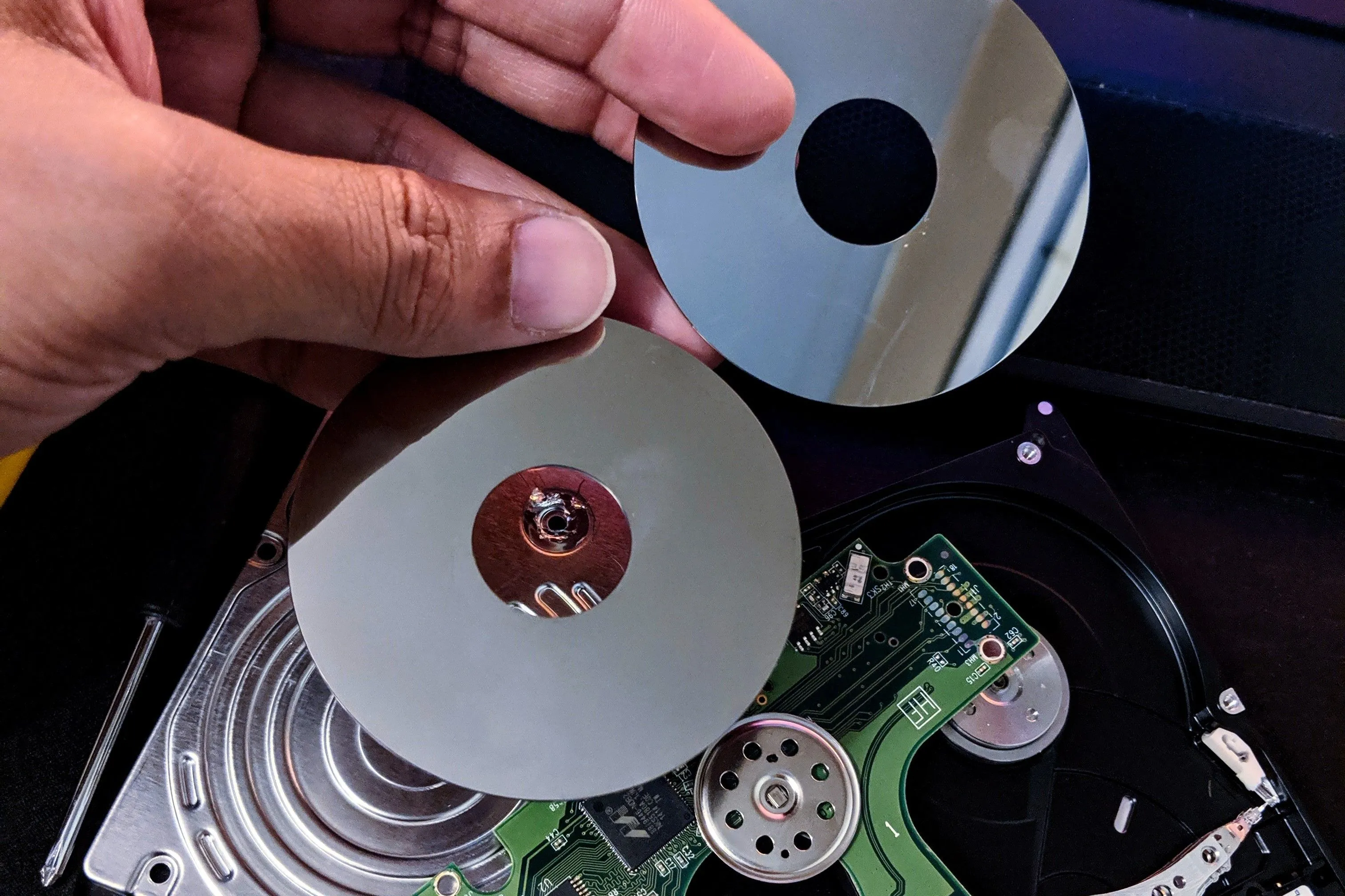 Các đĩa từ (platters) và đầu đọc của ổ cứng HDD cho laptop, minh họa linh kiện dễ hỏng.