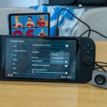 Hình ảnh một máy chơi game Nintendo Switch 2 đang được sử dụng với phụ kiện camera, minh họa sự đa dạng của các thiết bị đi kèm và tầm quan trọng của việc bảo vệ máy khỏi hư hại.