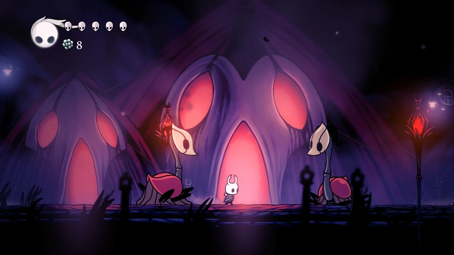 Hình ảnh nhân vật Hollow Knight đối mặt với kẻ thù trong một hang động tối, minh họa đồ họa ấn tượng của tựa game kinh điển.
