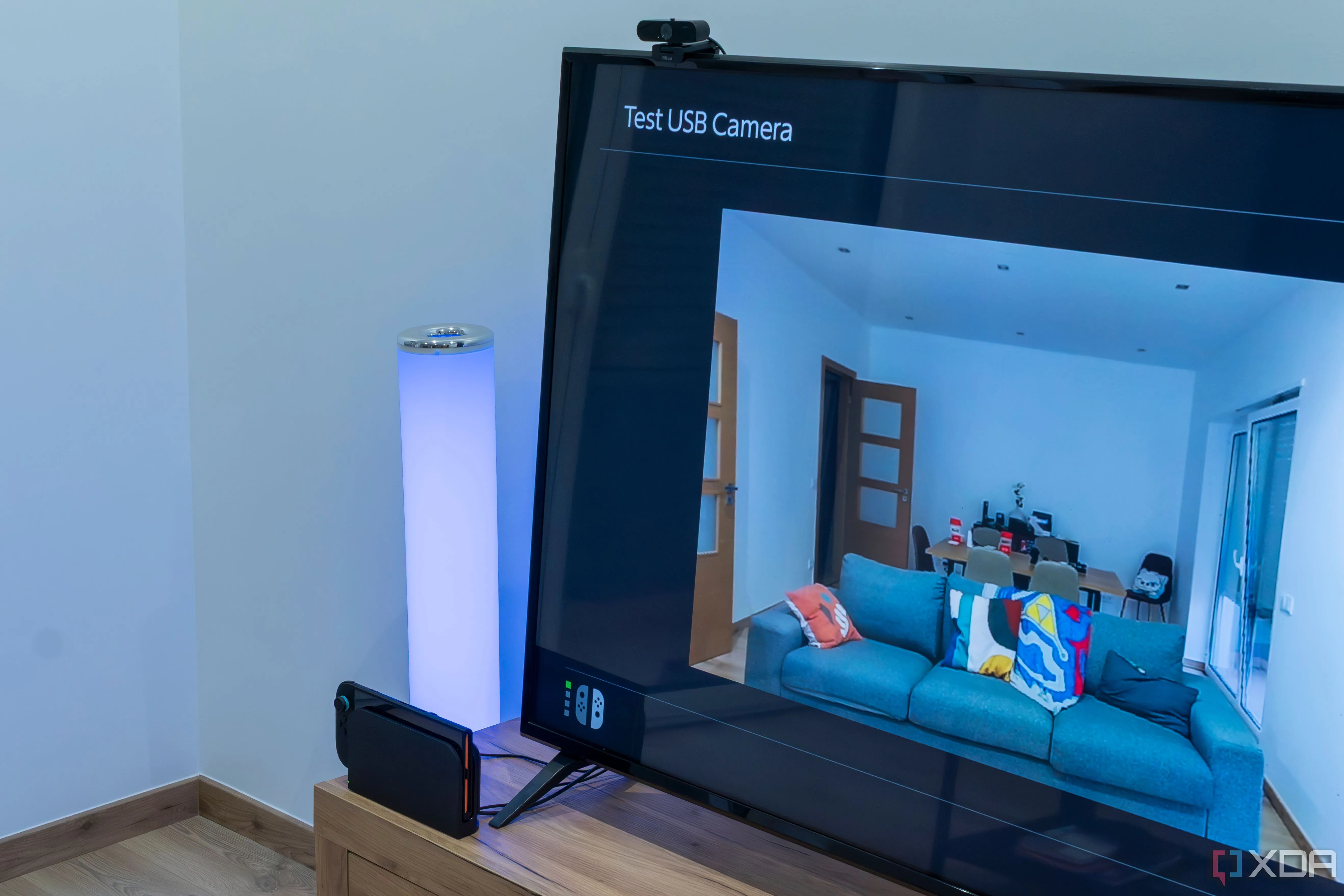Hình ảnh Nintendo Switch 2 trong dock, kết nối với webcam Trust USB Type-A cơ bản và hiển thị nguồn cấp video trên màn hình TV, chứng minh khả năng tương thích của webcam bên thứ ba.