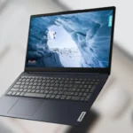 Laptop Lenovo IdeaPad 1i màu xanh, màn hình hiển thị giao diện Windows trên bàn làm việc