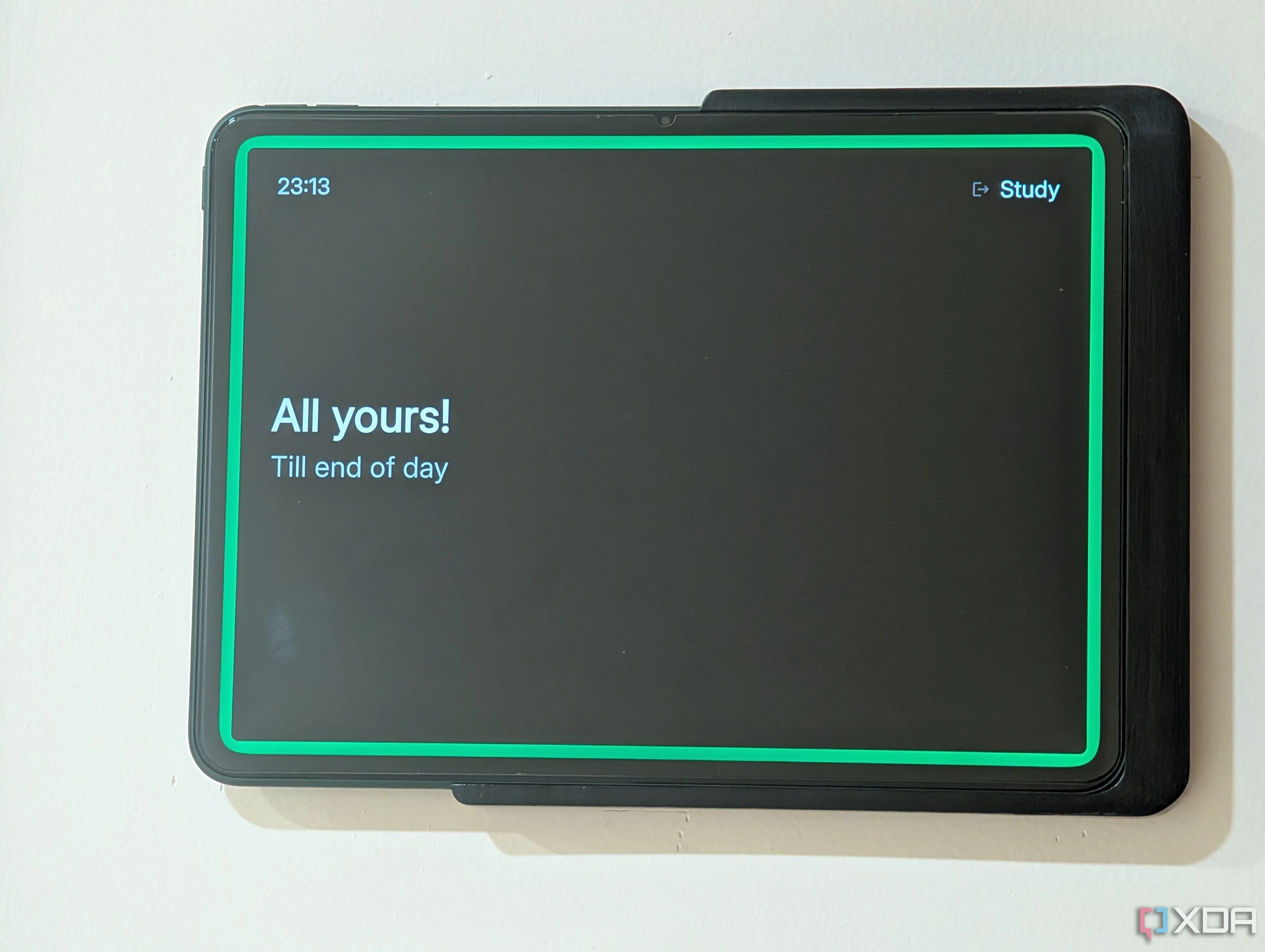 Màn hình Spacepad trên tablet được gắn bên ngoài văn phòng tại nhà, hiển thị trạng thái cuộc họp màu đỏ.