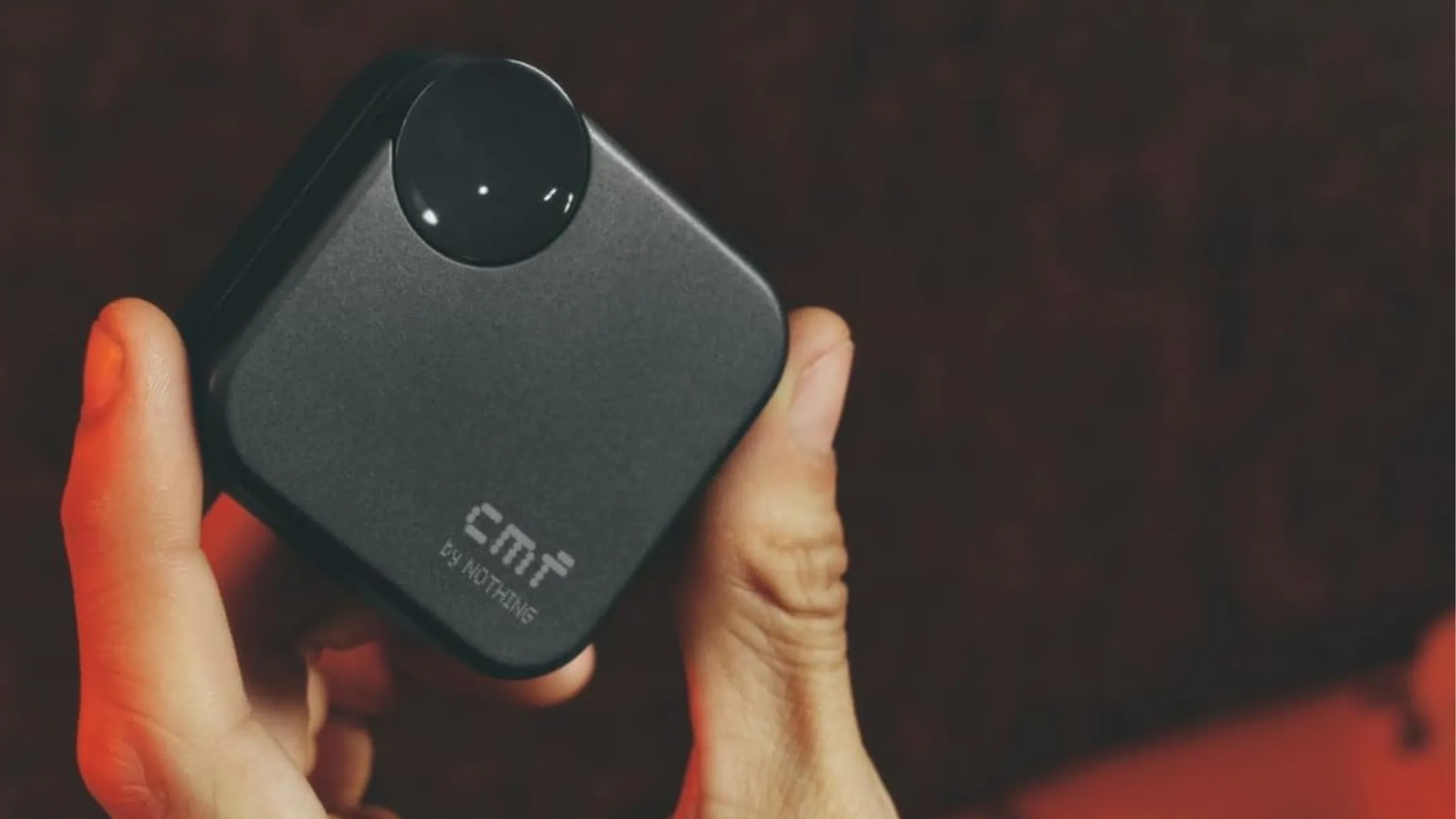 Người dùng cầm trên tay tai nghe không dây CMF Buds 2a màu xám