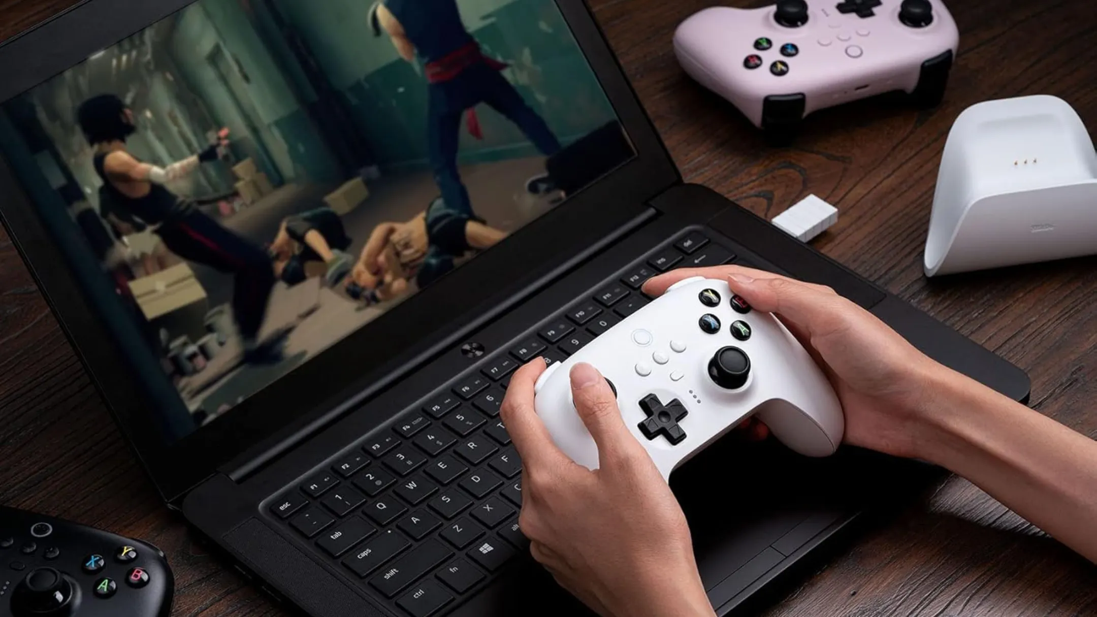 Người dùng chơi game trên laptop với tay cầm 8BitDo Ultimate Wireless