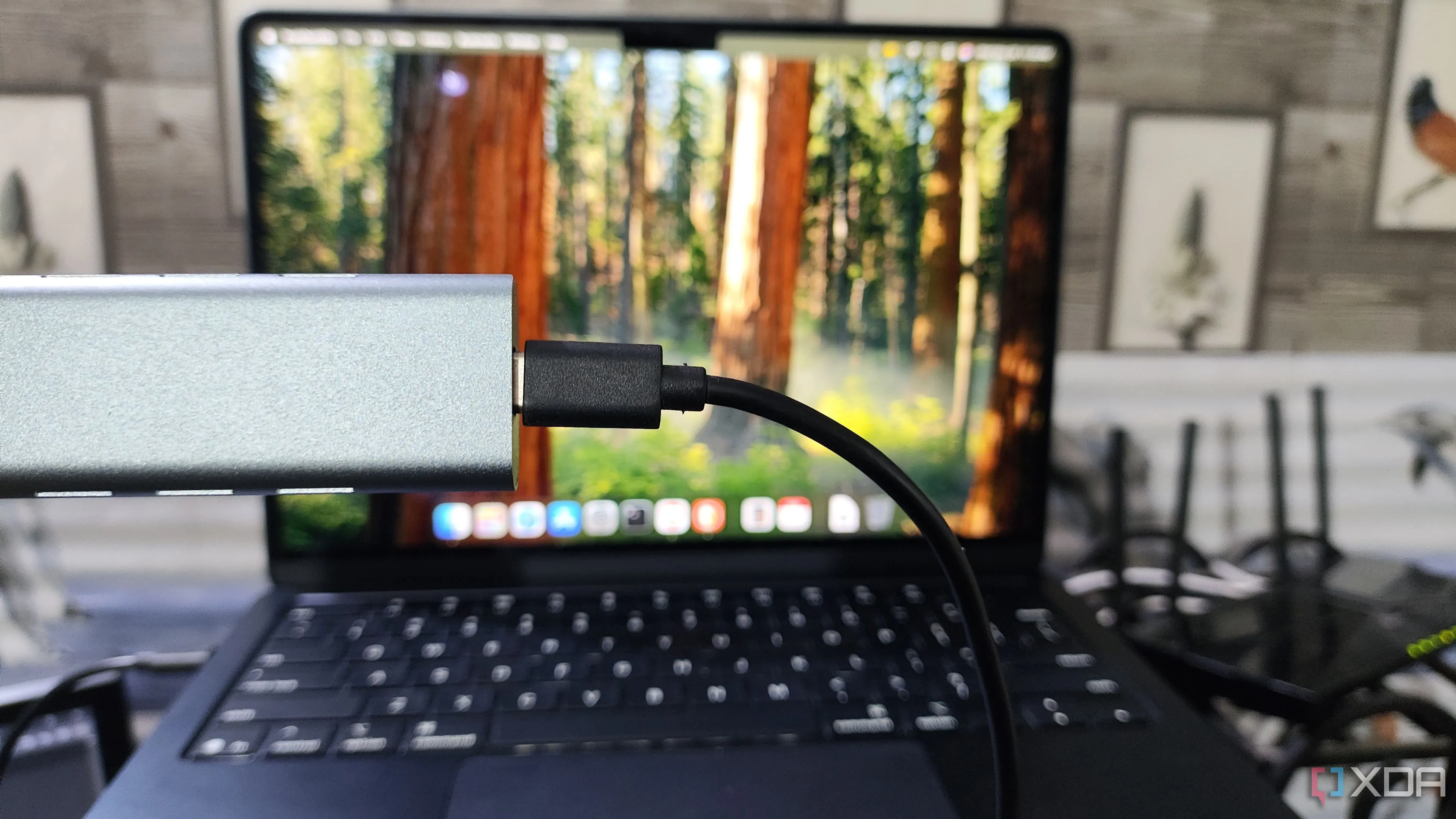 Người dùng đang cầm vỏ bọc NVMe SSD trước máy tính MacBook