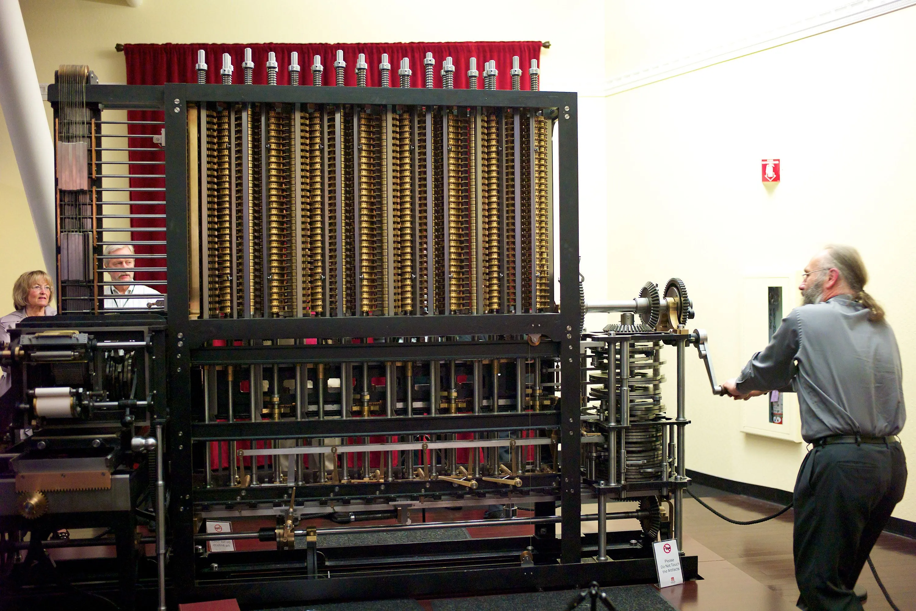 Người phụ nữ vận hành động cơ phân tích của Charles Babbage, minh họa nguyên lý tính toán cơ khí.