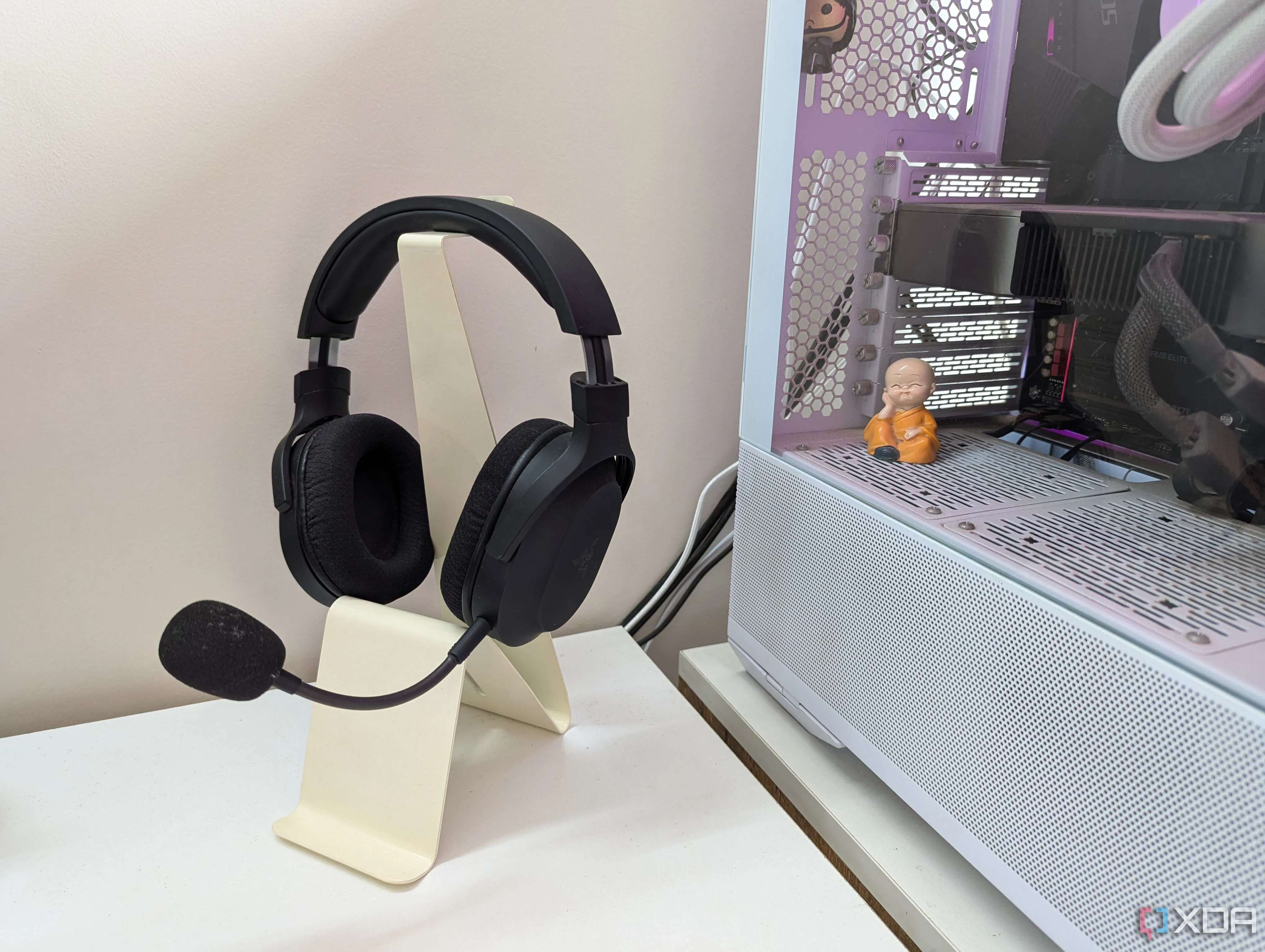 Tai nghe gaming đặt trên giá đỡ mua sẵn cạnh dàn máy tính PC trên bàn làm việc