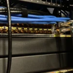 Thiết bị chuyển mạch mạng (network switch) với hệ thống dây cáp được sắp xếp gọn gàng trong môi trường home lab, minh họa cho việc tổ chức hạ tầng mạng chuyên nghiệp và an toàn.