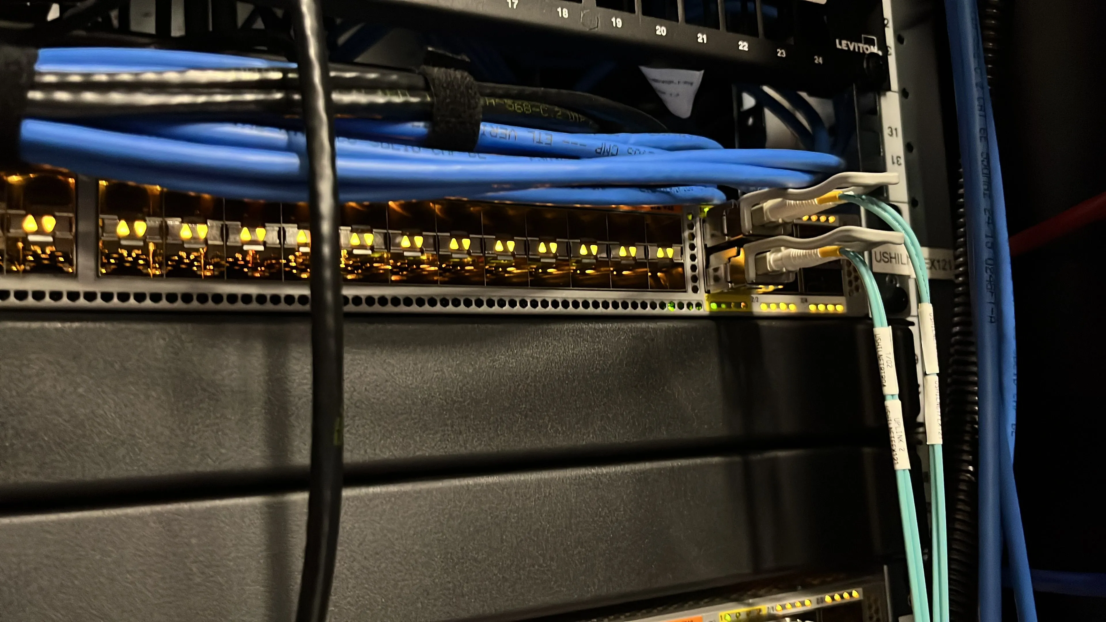 Thiết bị chuyển mạch mạng (network switch) với hệ thống dây cáp được sắp xếp gọn gàng trong môi trường home lab, minh họa cho việc tổ chức hạ tầng mạng chuyên nghiệp và an toàn.