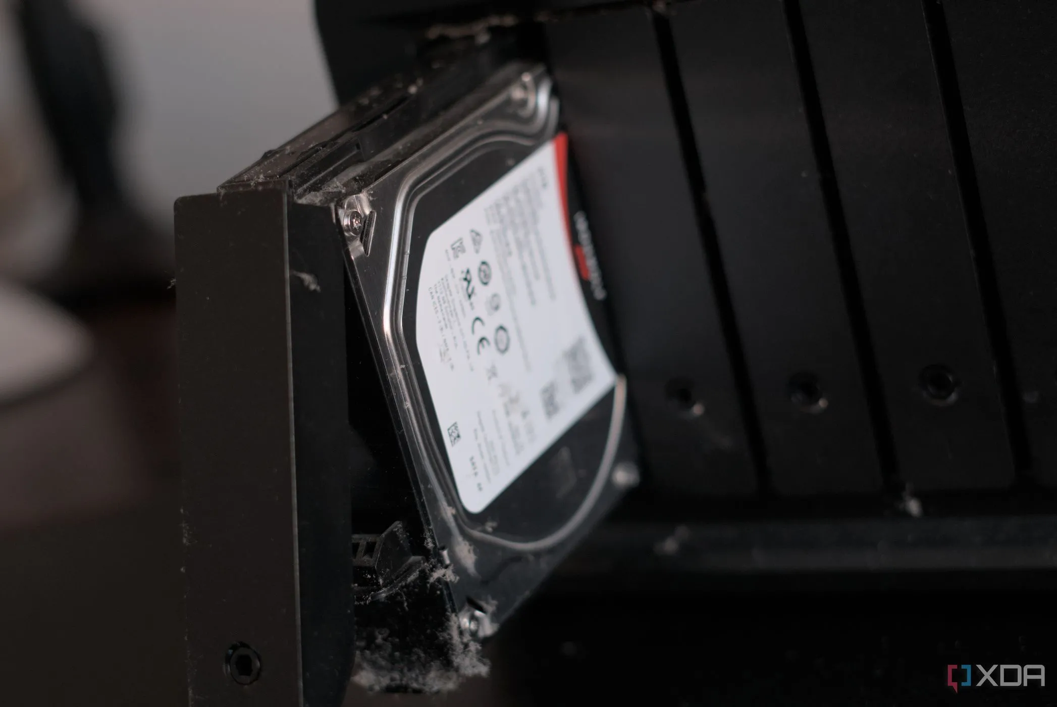 Thiết bị NAS Synology DiskStation DS1019+ với khay ổ đĩa mở, tượng trưng cho khả năng duy trì độ phản hồi của hệ thống dưới tải nặng nhờ bộ nhớ đệm SSD.